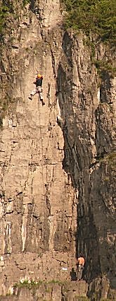 Climbers on a vertical face beside the River Meuse